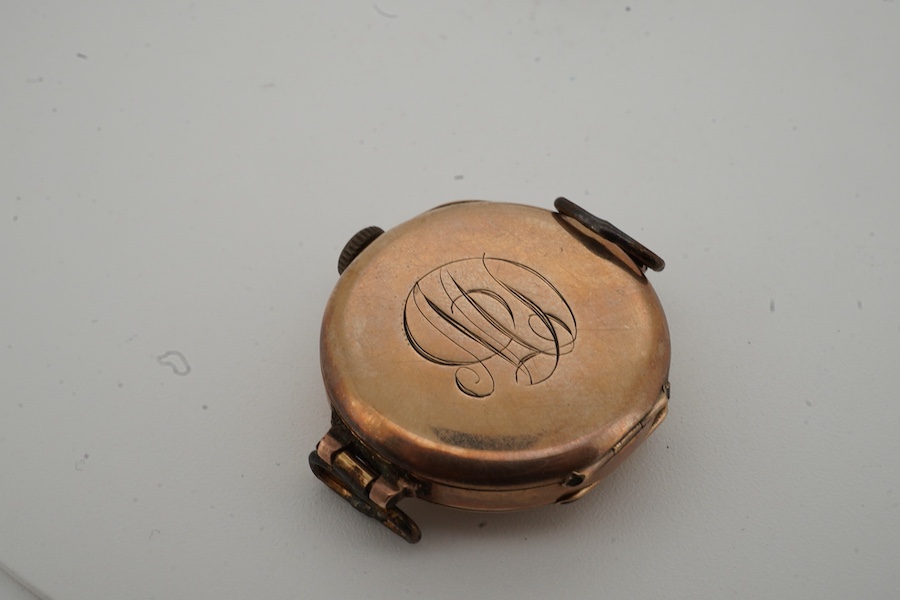 A lady's George V 9ct gold and enamel manual wind wrist watch, no strap, together with an unmounted oval cut quartz, carved with monogram, 19mm by 16mm.